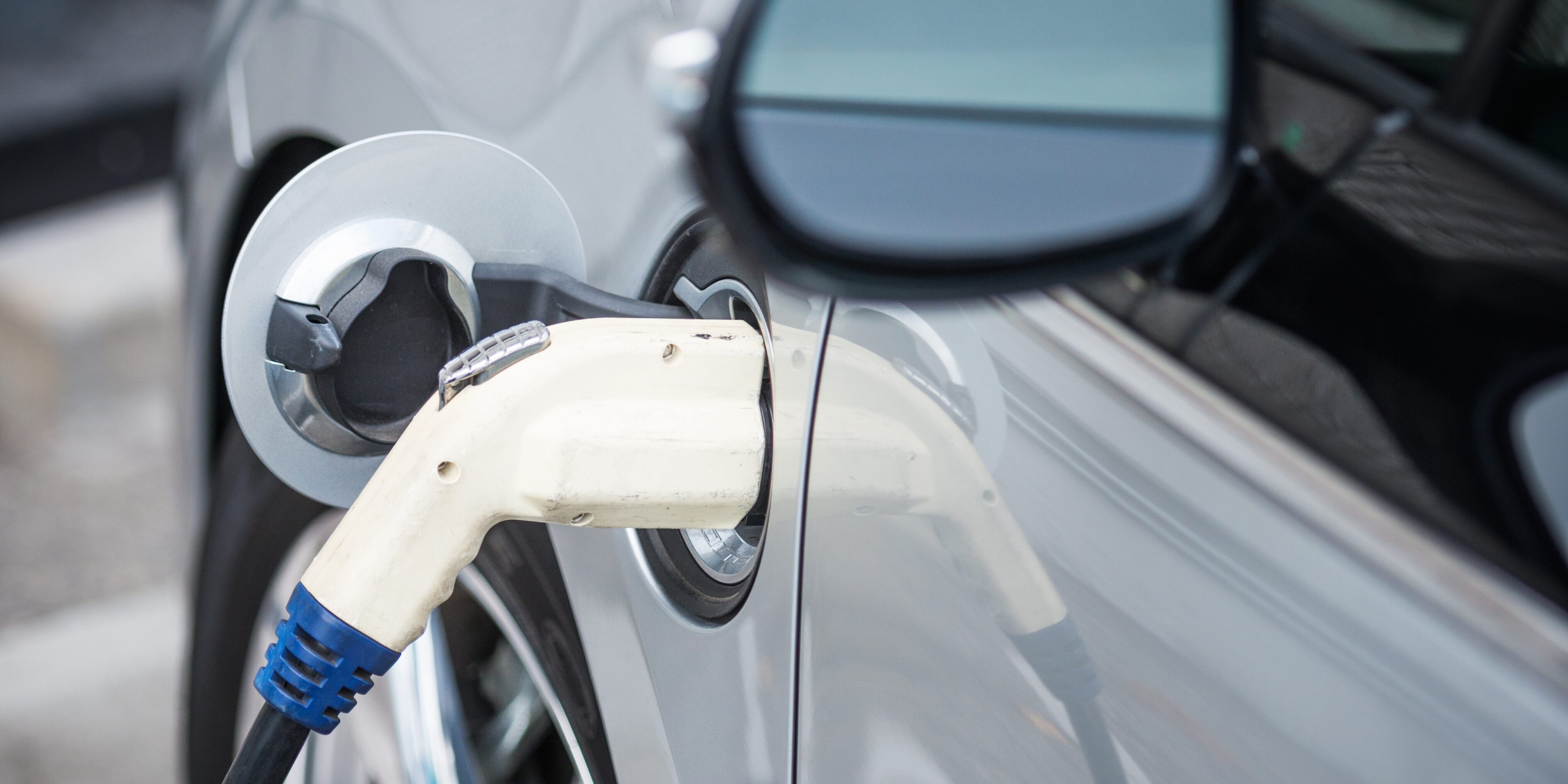 An electric vehicle plugged into an EV charger, highlighting charging risks and insurance considerations.