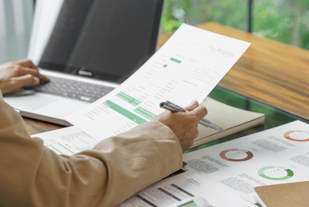 Business professional reviewing financial reports and insurance documents at a desk, highlighting risk management and coverage analysis for growing SMEs.