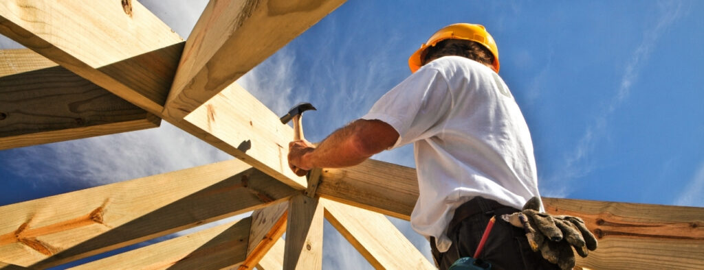 Builder working on a timber roof frame representing mandatory professional indemnity insurance for NSW builders